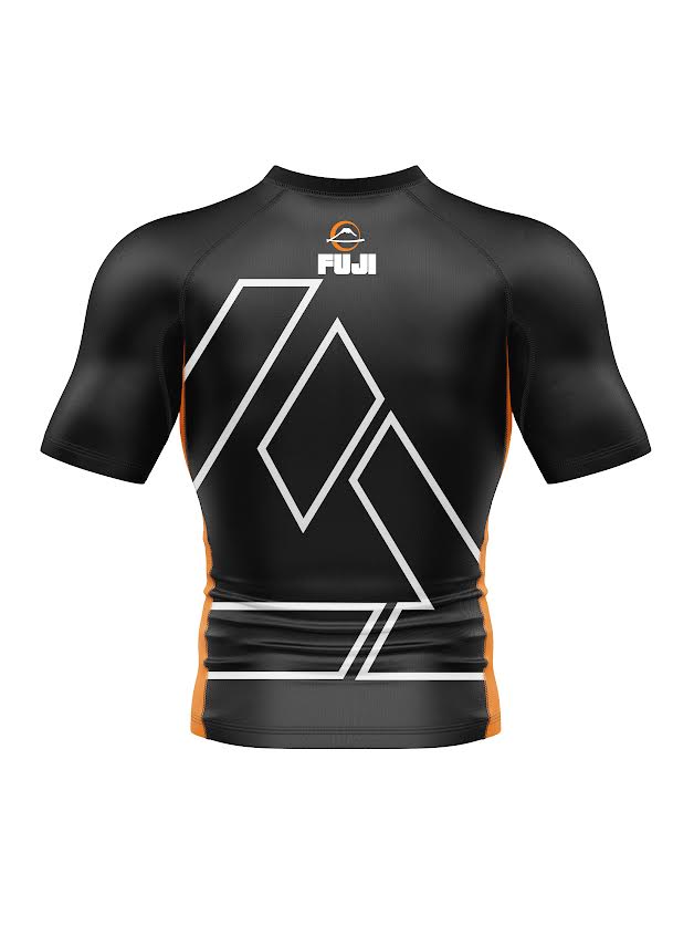 Kids Rilion Gracie Short Sleeve Standard Rashguard Orange features a black body with white geometric lines, orange accents, and the FUJI logo at the top center of the back. Displayed on a plain white background.