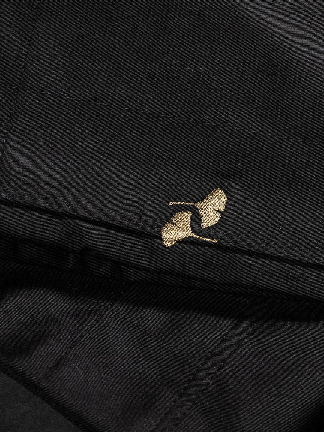 A small gold embroidered logo of a stylized woman in high heels appears on the black fabric of the Heritage Keishō Edition Bundle.