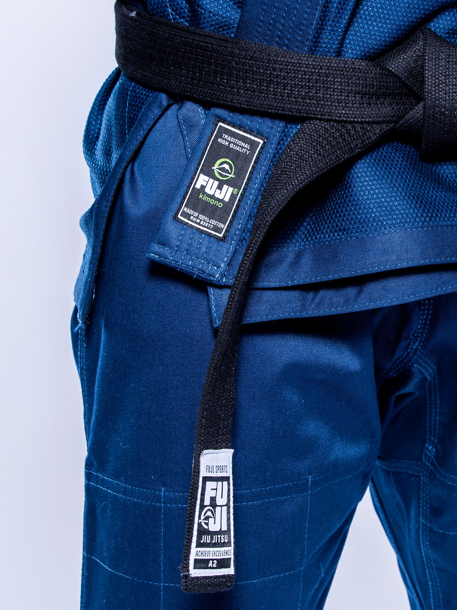 A person wearing the Lightweight BJJ Gi Navy, tied with a black belt. The image is cropped to highlight the torso and waist, focusing on the gi’s details.