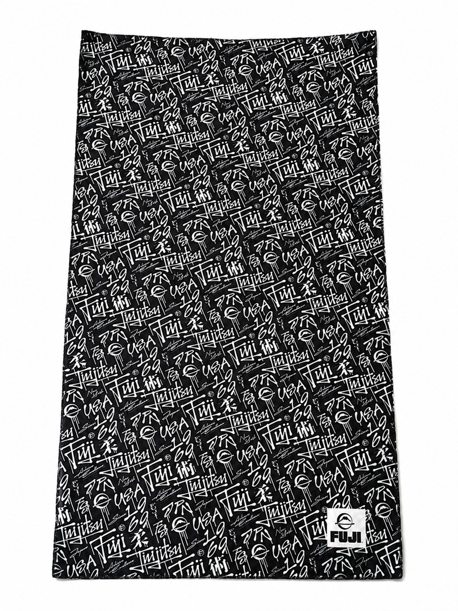 A black rectangular Gym Towel featuring white abstract text and symbols, with a small Fuji logo in the bottom right corner.
