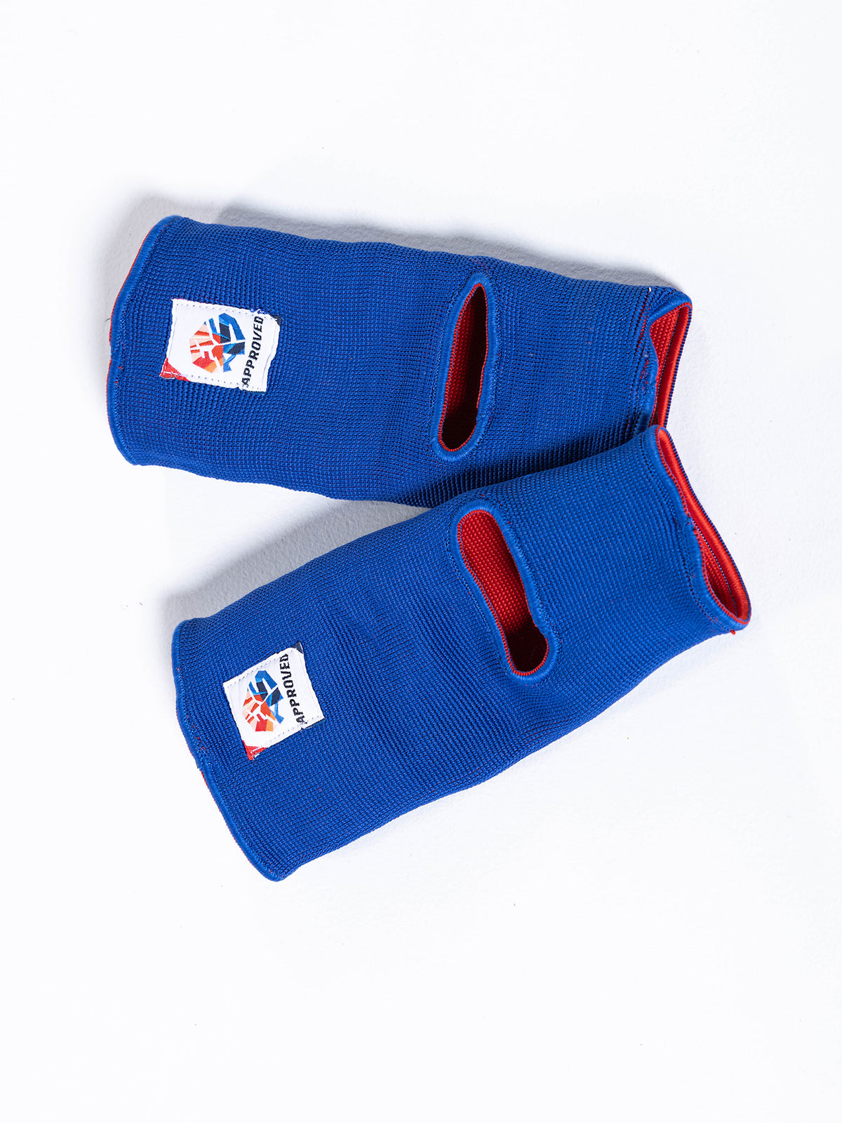 A pair of FIAS Sambo Beach Ankle Support Reversible in blue and red, featuring thumb holes and white logo patches, displayed on a white background.