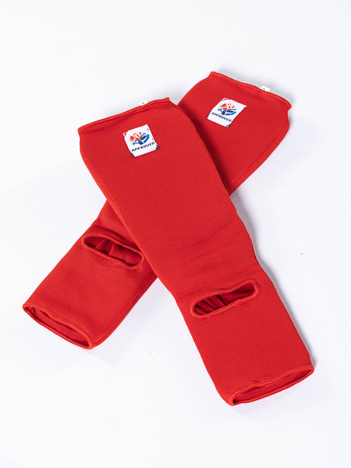Two red FIAS Sambo Combat Shin Guards with thumb holes are crossed on a white background. Each guard features a small rectangular label with a logo and text.