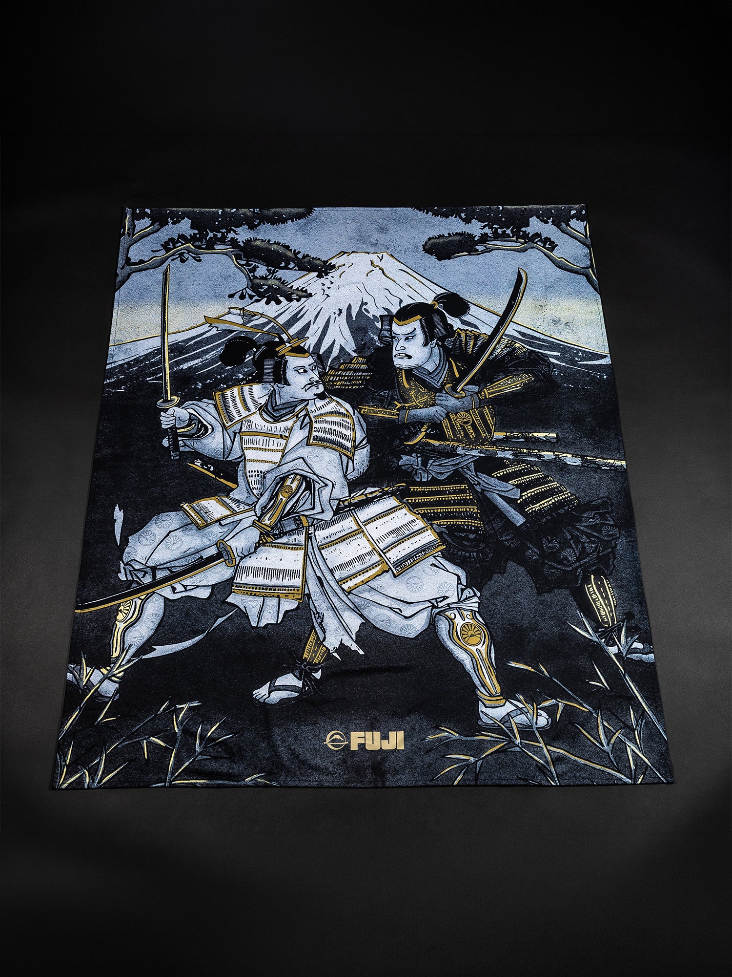 Two samurai in traditional armor duel with swords in front of Mount Fuji, trees in the background. The detailed illustration, rendered in shades of blue, white, and gold, is branded with “Womens Heritage Keisho Lightweight BJJ Gi Black” at the bottom.