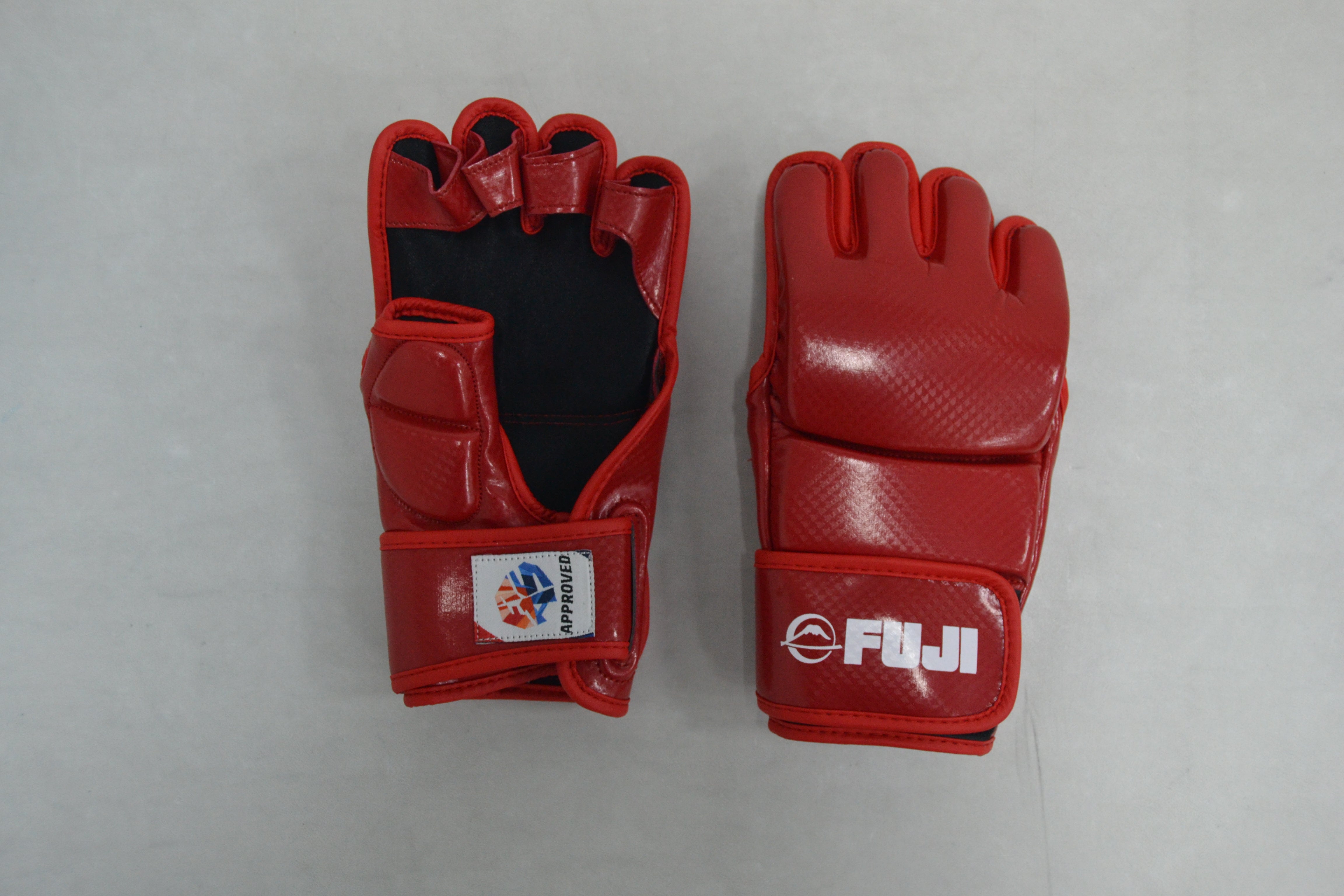 Two FIAS Sambo Combat Gloves Red are placed side by side on a light surface. One glove reveals the palm with black padding and a logo patch, while the other displays the FUJI logo on the back.