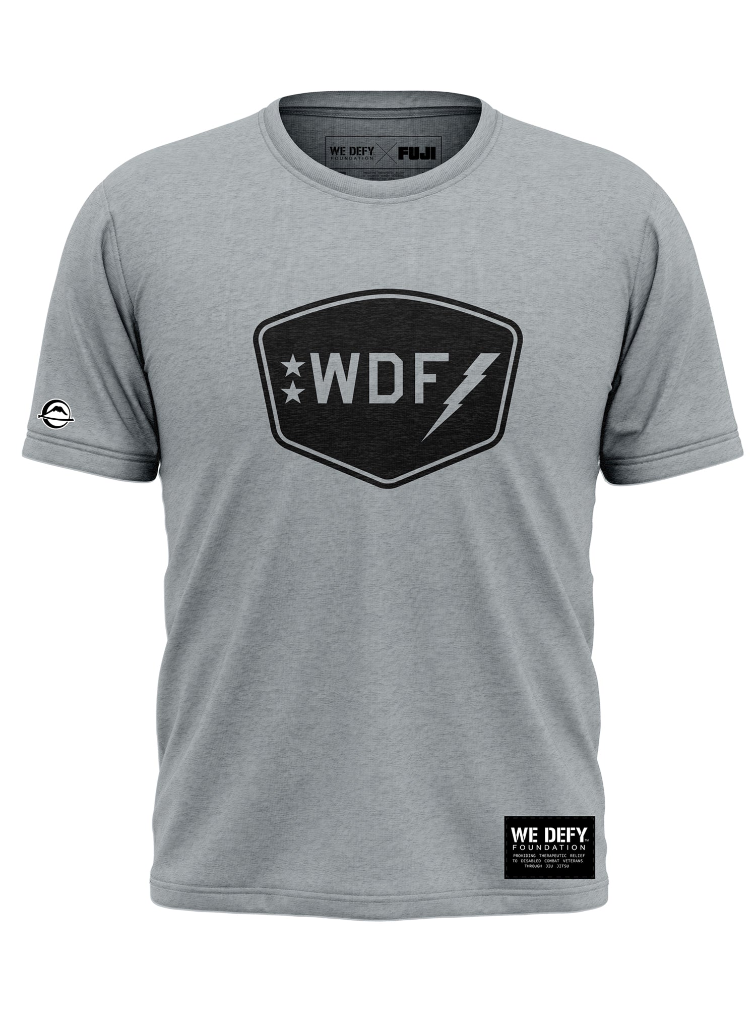 The We Defy Badge T-Shirt Grey features a black shield emblem with "WDF," two stars, and a lightning bolt on the chest, a small circular logo on the left sleeve, and a black label on the lower front hem.