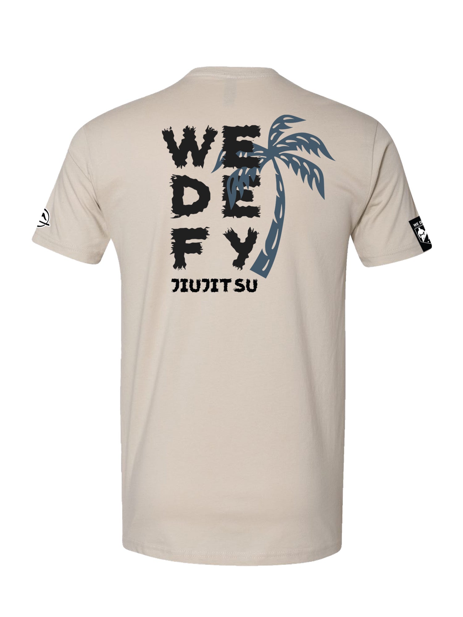 The We Defy Beach Vibes T-Shirt Sand features black bold "WE DEFY JIU JITSU" text on the back, with a gray palm tree partially covering "DEFY," plus logo prints on both sleeves.