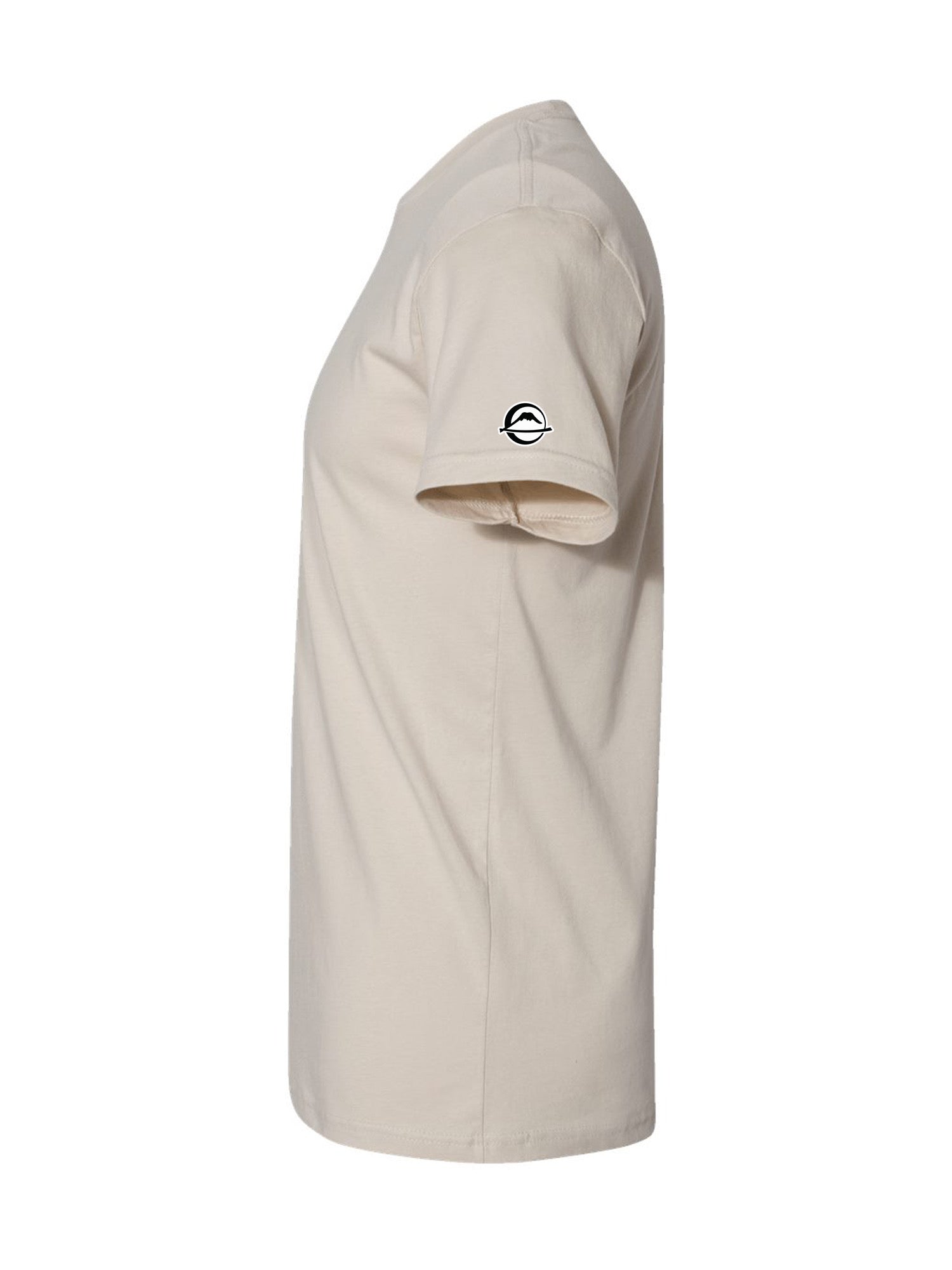 The We Defy Beach Vibes T-Shirt Sand is displayed from the side, featuring a small black and white circular logo on the left sleeve against a plain white background.